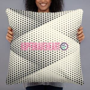 A person holding up a pillow with a design on it.