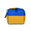 A blue and yellow bag is sitting on the ground.