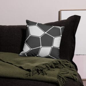 A black and white pillow sitting on top of a bed.