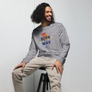A man sitting on top of a stool wearing a sweatshirt.