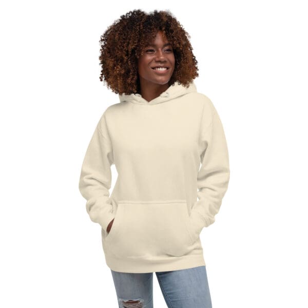 A woman wearing a hoodie with her hands in pockets.