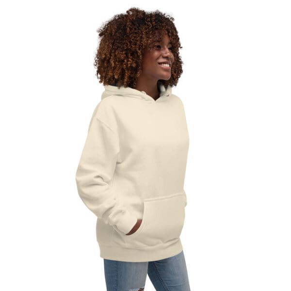 A woman wearing a white hoodie with her hands in pockets.