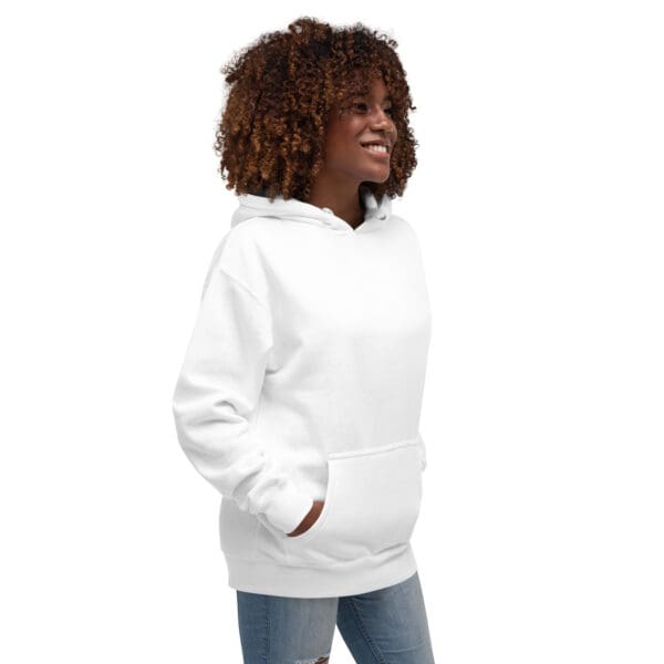 A woman wearing a white hoodie with her hands in pockets.