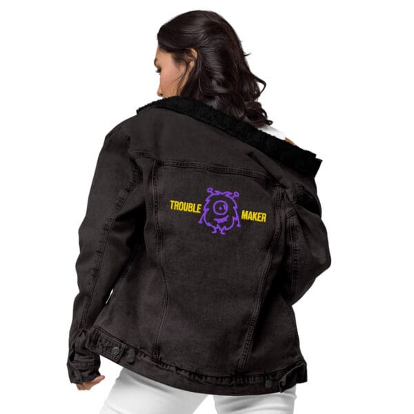 A woman wearing a black jacket with purple and yellow accents.