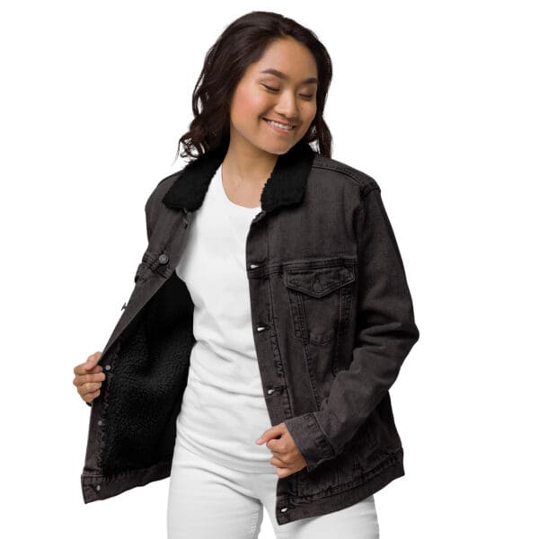 A woman is smiling and holding her jacket open.